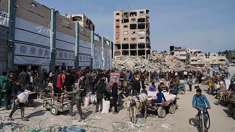Palestinesi ricevono sacchi di farina e altri aiuti umanitari distribuiti dall'UNRWA, l'agenzia delle Nazioni Unite che aiuta i rifugiati palestinesi a Jabaliya, nella Striscia di Gaza.