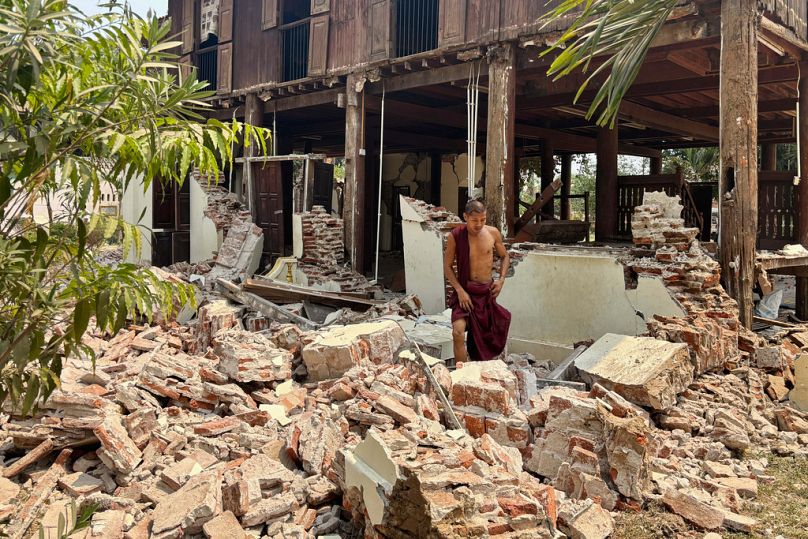Un moine bouddhiste marche près d'un bâtiment endommagé dans l'enceinte d'un monastère après un tremblement de terre, vendredi 28 mars 2025 à Naypyidaw, Myanmar.