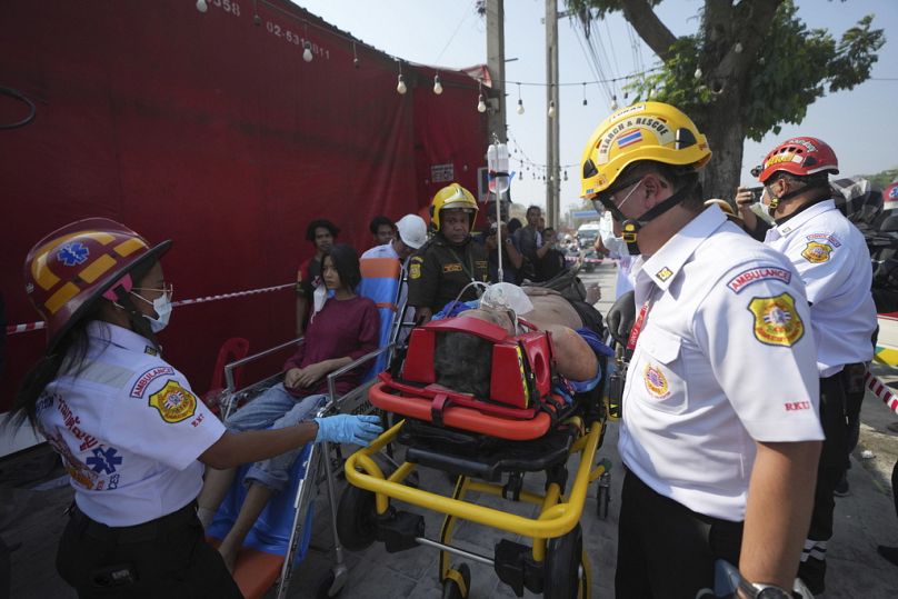 Des sauveteurs s'occupent des blessés sur le site d'une tour en construction qui s'est effondrée après un tremblement de terre de magnitude 7,7 à Bangkok, Thaïlande.