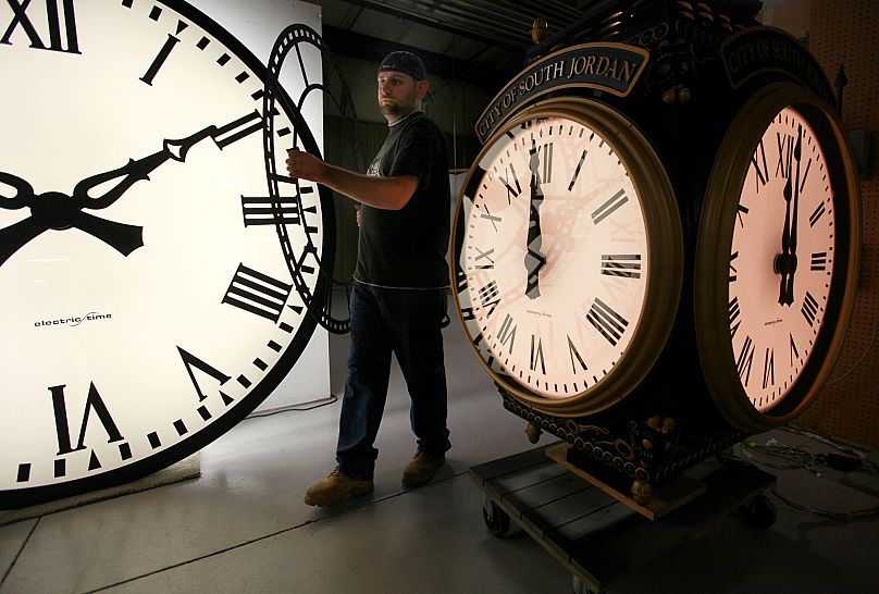 Na zdjęciu z czwartku, 3 listopada 2011 r., Dan LaMoore z Electric Time Company przesuwa tarczę zegara w swoim zakładzie w Medfield, Massachusetts