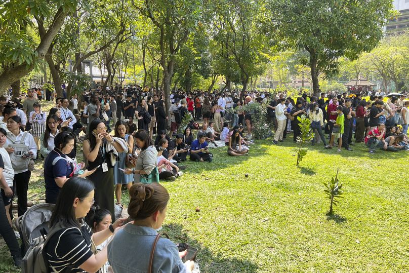 Des personnes cherchent à s'abriter dans le parc Benjasiri de Bangkok après qu'un tremblement de terre ait secoué les tours voisines, le 28 mars 2025. 
