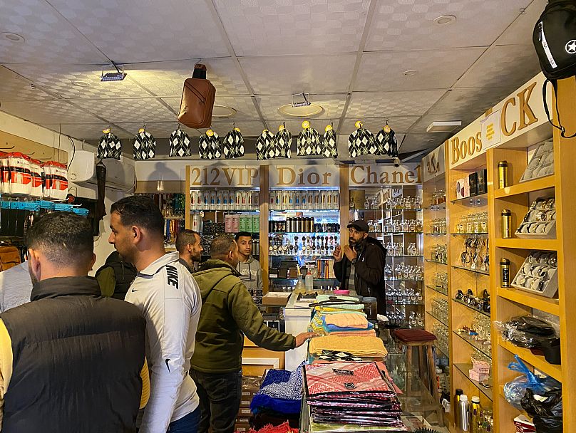 بائع عطور في دير البلح يشرح للزيائن سبب ارتفاع أسعار المنتجات بتاريخ 27 آذار مارس