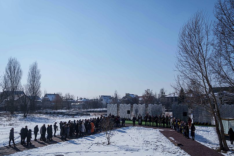 Ukraińcy biorą udział w ceremonii upamiętniającej zabitych cywilów w Buczy. 