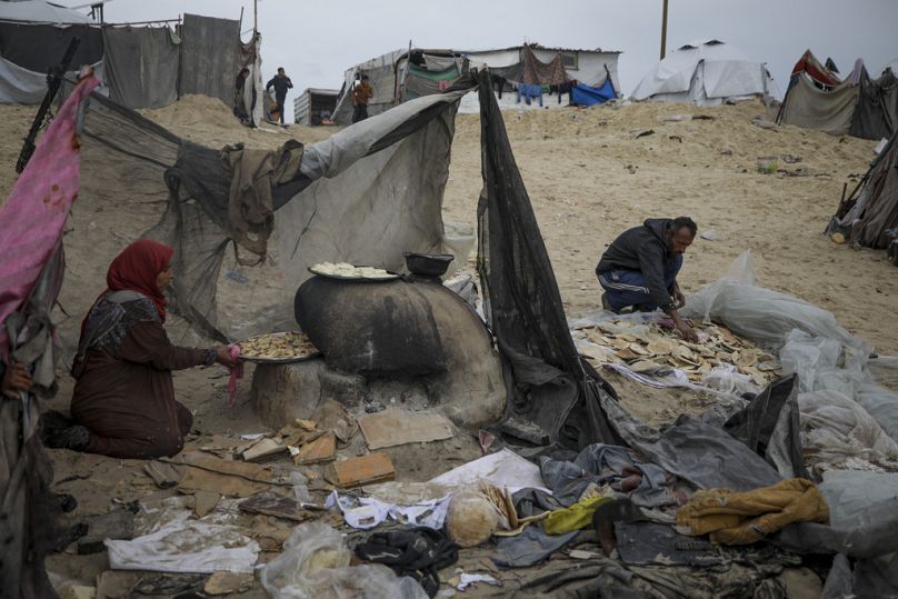 Des habitants de la ville de Gaza, font du pain dans un camp de tentes pour Palestiniens déplacés d'al Muwasi, Rafah