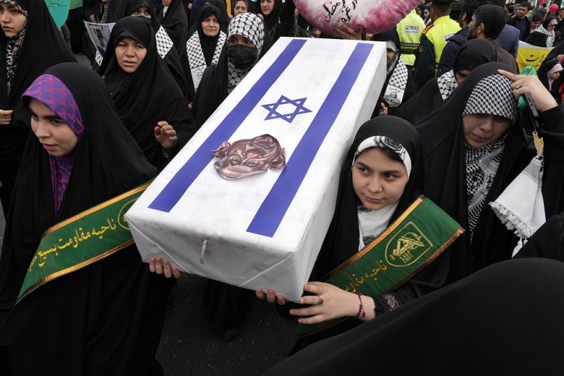 متظاهرون إيرانيون يحملون نعشًا رمزيًا لإسرائيل مع صورة كاريكاتورية لرئيس الوزراء الإسرائيلي بنيامين نتنياهو خلال يوم القدس السنوي إيران، الجمعة، 28 مارس/آذار 2025. 