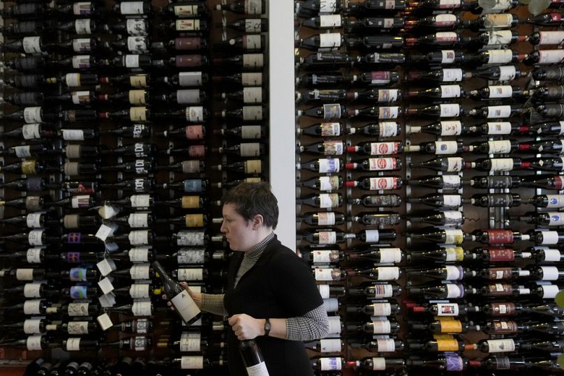 Emma Drew, direttrice generale dell'enoteca Biondivino, davanti alle bottiglie di vino italiano esposte nel negozio di San Francisco, 14 marzo 2025