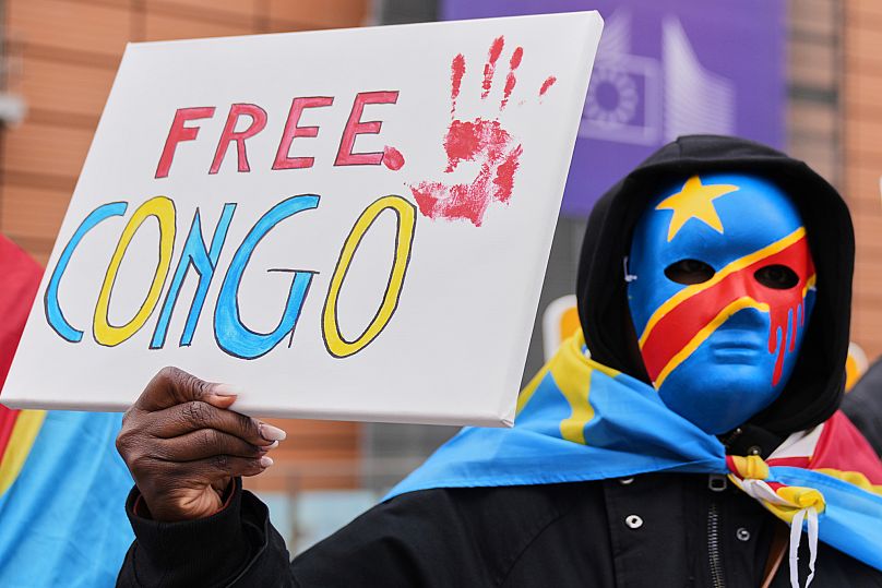 Demonstrant prokongijski trzyma znak przed spotkaniem ministrów spraw zagranicznych UE w budynku Rady Europejskiej w Brukseli, poniedziałek, 17 marca 2025 r.