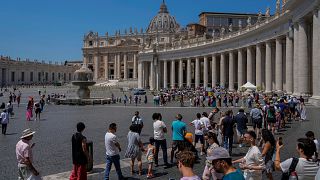 Tourists and faithful wander in St. Peter's Square at the Vatican. 