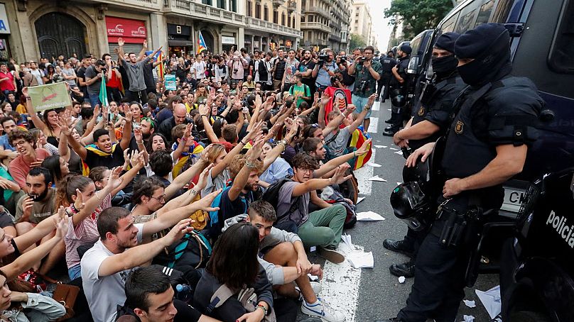 A függetlenség hívei és a spanyol rendőrség a törvénytelen népszavazás napján