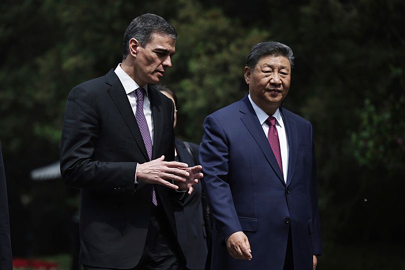 Xi Jinping e Pedro Sanchez falam enquanto caminham pelos jardins da Casa de Hóspedes Diaoyutai após uma reunião em Pequim