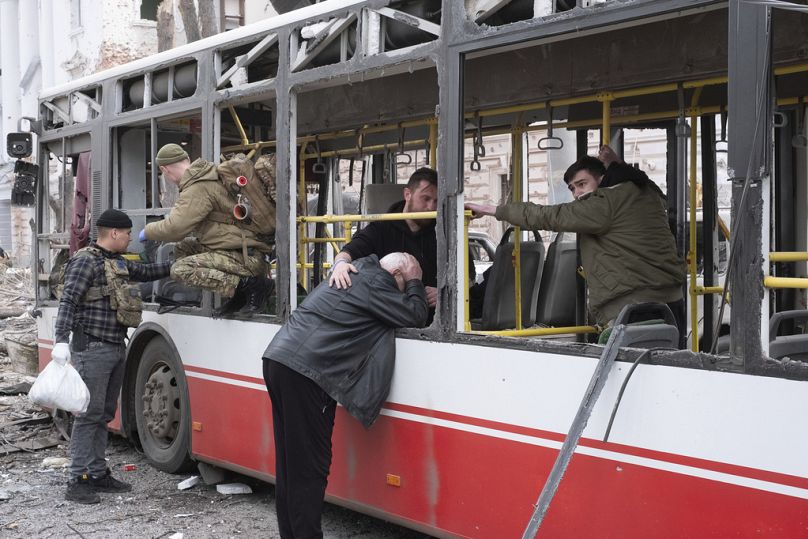 Un homme pleure en s'appuyant sur le bus qui a été touché par un missile russe à Soumy, en Ukraine, dimanche 13 avril 2025.