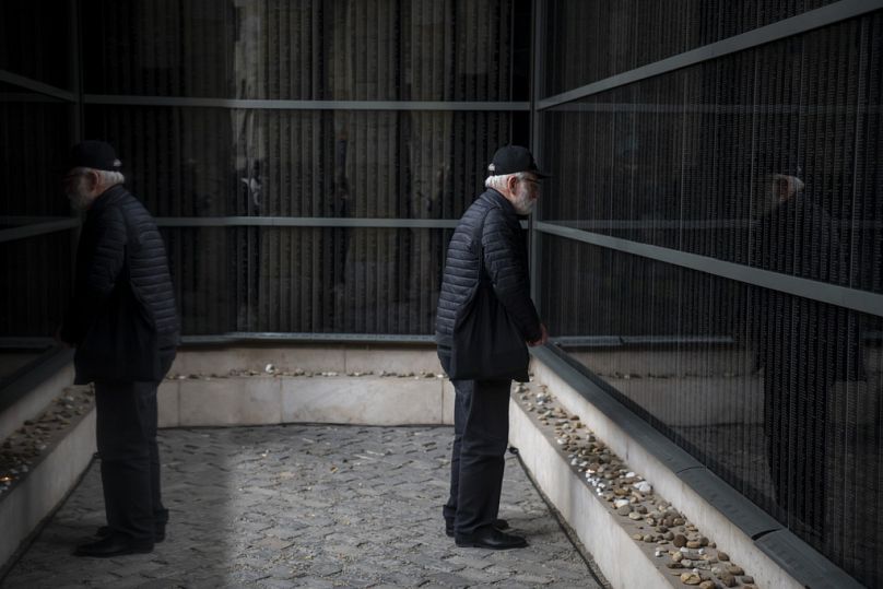 Un homme devant le mur du souvenir, qui énumère les noms des victimes, lors d'un service commémoratif au Centre commémoratif de l'Holocauste à Budapest, en janvier 2025.