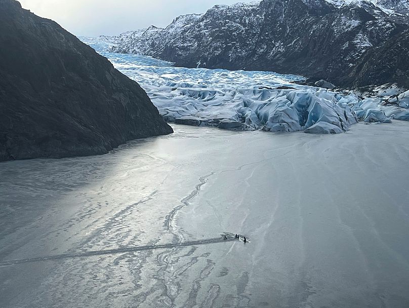 Esta foto, proporcionada por la Guardia Nacional de Alaska, muestra un avión parcialmente sumergido en el hielo del lago Tustumena, al pie de un glaciar, 24 de marzo 2025
