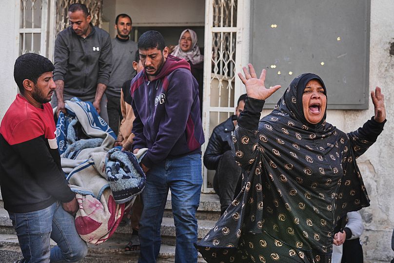 Palestyńska kobieta reaguje, gdy inni niosą ciało jej krewnego, zabitego w izraelskim nalocie, przygotowując się do pochówku w szpitalu Shifa w mieście Gaza, 