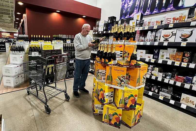 Kupujący sprawdza butelkę hiszpańskiego wina musującego w sklepie monopolowym w Niles, Illinois, w czwartek, 3 kwietnia 2025 r. 