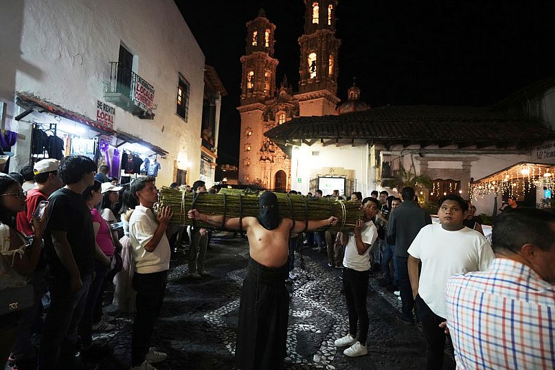 Un pénitent porte un fagot de branches épineuses lors d'une procession de la Semaine Sainte à Taxco, au Mexique, le jeudi 17 avril 2025.