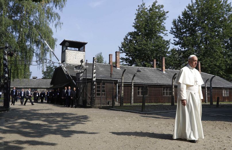 Franciszek przekracza bramę nazistowskiego obozu koncentracyjnego w Auschwitz