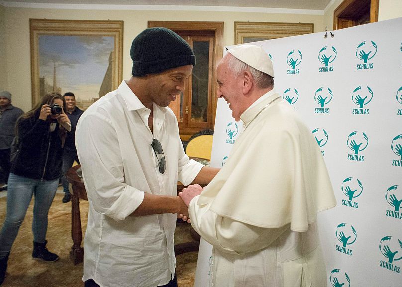 El Papa Francisco abraza a la estrella del fútbol brasileño Ronaldinho durante una reunión con Scholas Occurrentes, una organización educativa fundada por el Papa, 2016.
