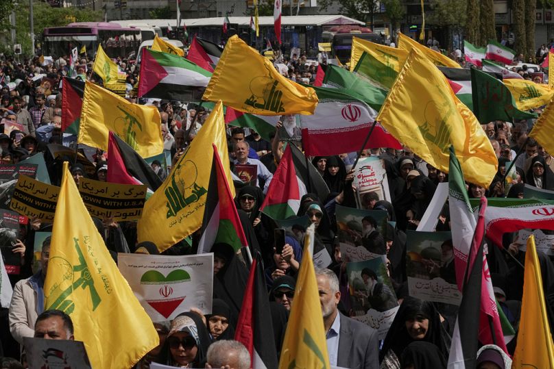 متظاهرون إيرانيون يرفعون أعلام إيران وفلسطين وحزب الله اللبناني خلال تظاهرة مناهضة لإسرائيل في طهران، يوم الجمعة 11 أبريل 2025.