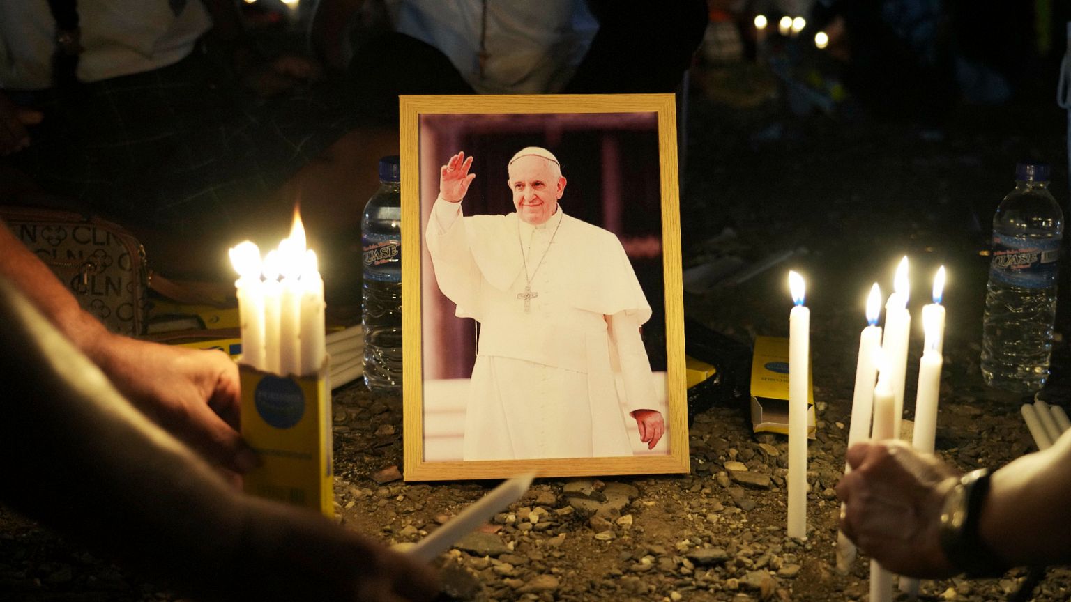 People light candles around a portrait of Pope Francis in East Timor where the late pope led a mass during his visit in 2024, 25 April, 2025