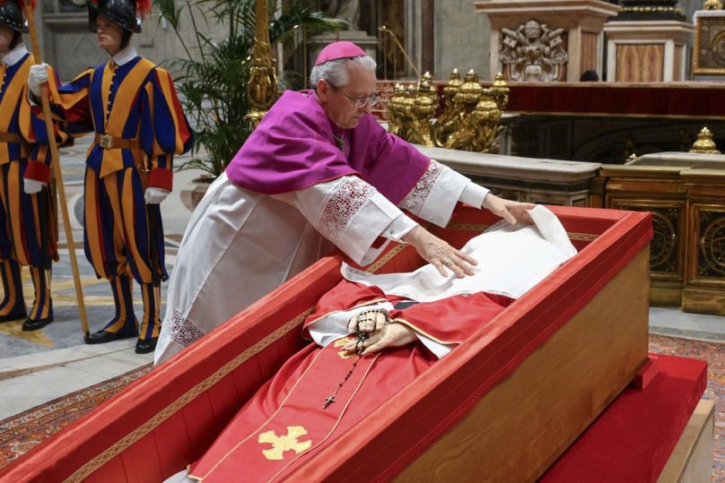 Il cerimoniere vaticano, l'arcivescovo Diego Giovanni Ravelli, copre il volto del defunto Papa Francesco con un drappo di seta prima di chiudere la bara, 25 aprile 2025