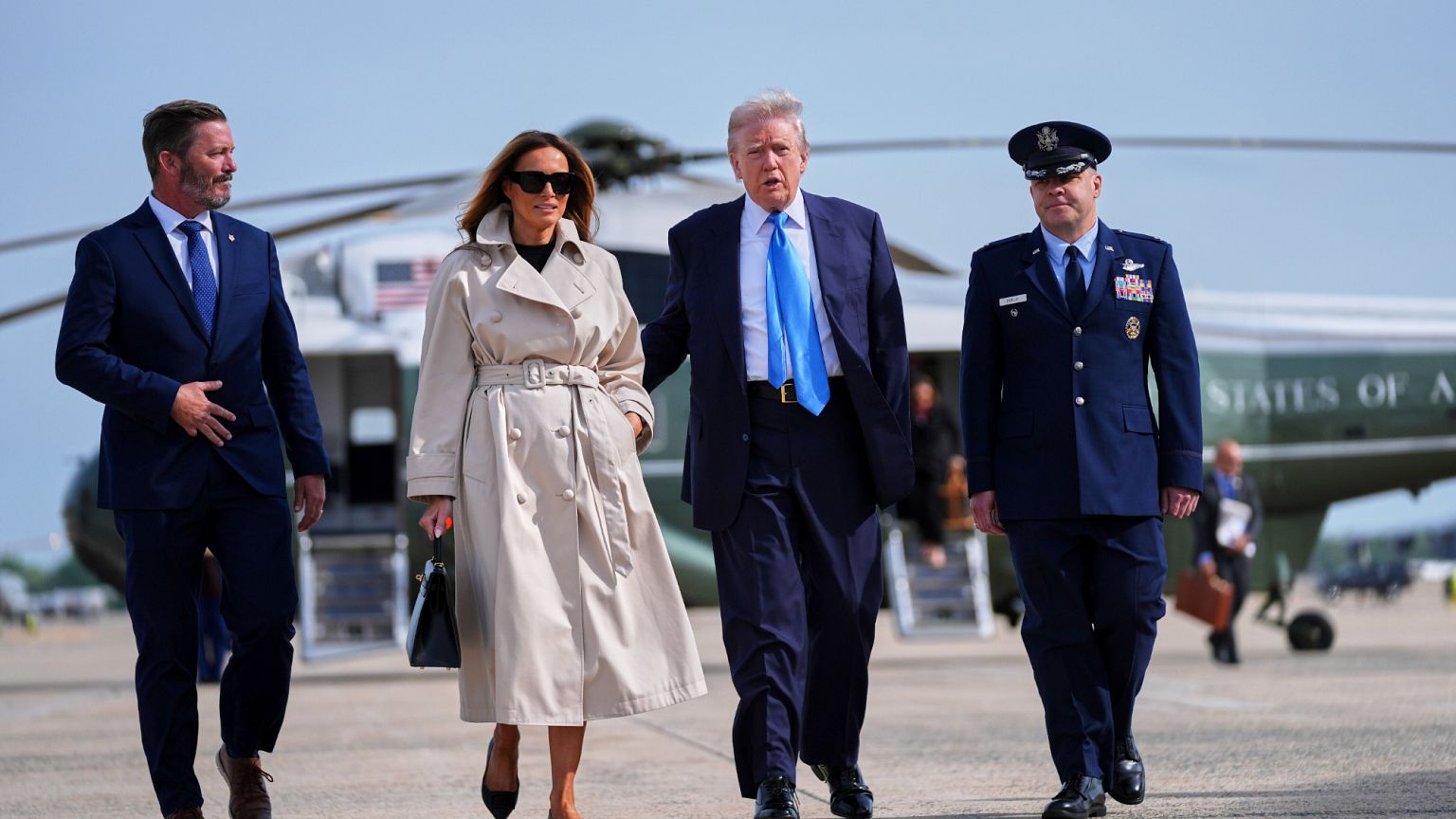 President Donald Trump, escorted by Col. Paul Pawluk, Vice Commander of the 89th Airlift Wing, and first lady Melania Trump, walk to board Air Force One for a trip