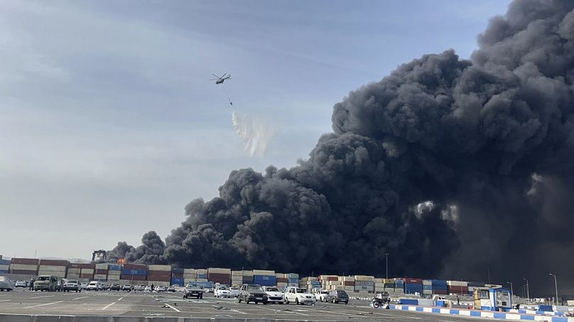 Sur cette photo fournie par l'agence de presse des étudiants iraniens, ISNA, un hélicoptère largue de l'eau sur le feu après une explosion massive qui a secoué le port
