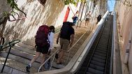 People climb stairs in Lisbon old town after the escalator stopped working following a power outage, 28 April, 2025