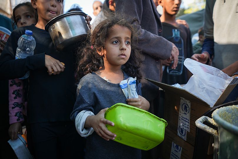 فتاة فلسطينية صغيرة تقف في طابور للحصول على الطعام في دير البلح، قطاع غزة، الاثنين 18 نوفمبر/تشرين الثاني 2024.