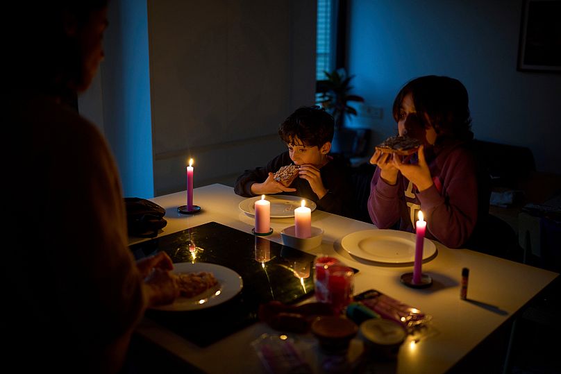 A family eats a snack by candlelight during a blackout in Barcelona, 28 April, 2025