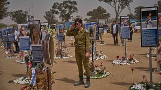 An Israeli soldier salutes as people observe two minutes of silence as air raid sirens sound marking the Israel's annual Memorial Day, near Kibbutz Reim, Israel, 30.04.2025