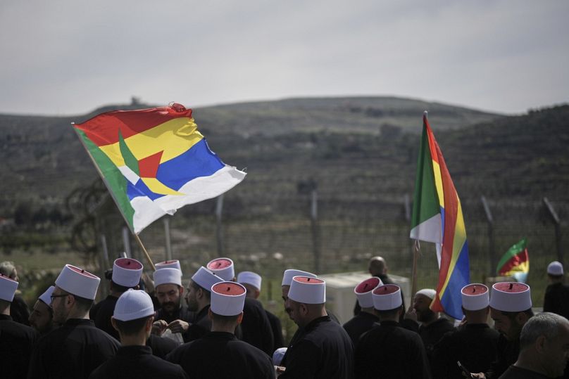 دروز قرب الحدود ينتظرون وصول حافلات لتنقلهم من سوريا إلى مجدل شمس في الجولان المحتل، 14 مارس 2025.