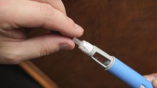 A man prepares an injection of semaglutide.