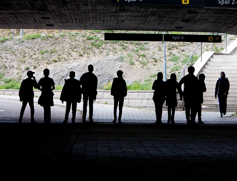 Alunos migrantes caminham sob uma ponte ferroviária Em Flen, 30 de agosto de 2018