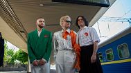 Die ukrainische Band Ziferblat steht unter der Infotafel «Eurovision Express», während sie am 01.05.2025 am Hauptbahnhof in Kiew, Ukraine, ankommt, um einen Zug zu nehmen