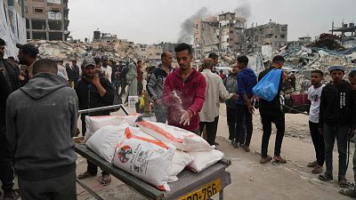 Palestinians receive bags of flour and other aid distributed by UNRWA in Jabaliya, 1 April, 2025