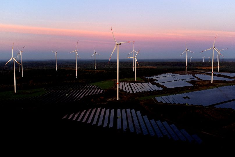 Wind turbines operate as the sun rises at the Klettwitz Nord solar energy park near Klettwitz near Klettwitz, Germany.