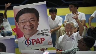 Supporters of ruling party People's Action Party (PAP) cheer as they hold a picture of Prime Minister Lawrence Wong's as they wait for results of the general election.