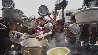 کودکان فلسطینی هنگام دریافت کمک‌های غذایی در خان یونس (نوار غزه، ۳ مه ۲۰۲۵)