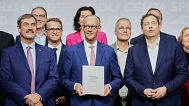 CSU leader Markus Soeder, CDU leader Friedrich Merz and SPD leader Lars Klingbeil stand together after signing the coalition treaty in Berlin, Germany, Monday, May 5, 2025.