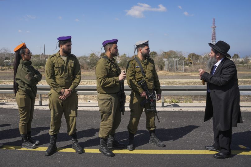 جنود إسرائيليون ورجل من الحريديم قرب كيبوتس نير عوز، 26 فبراير 2025.