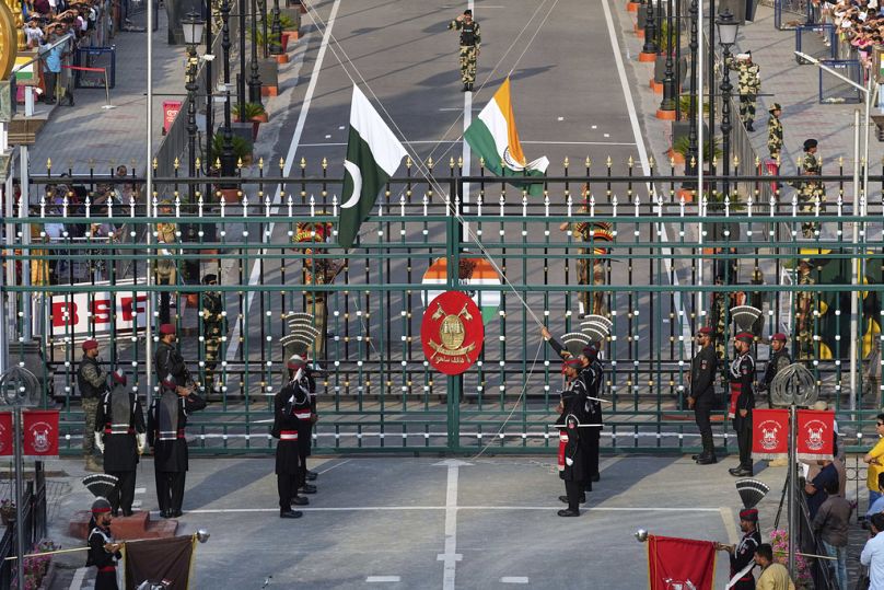 Los Rangers de Pakistán y los soldados de las Fuerzas de Seguridad Fronteriza de la India bajan sus banderas durante una ceremonia de clausura diaria en el puesto de Wagah