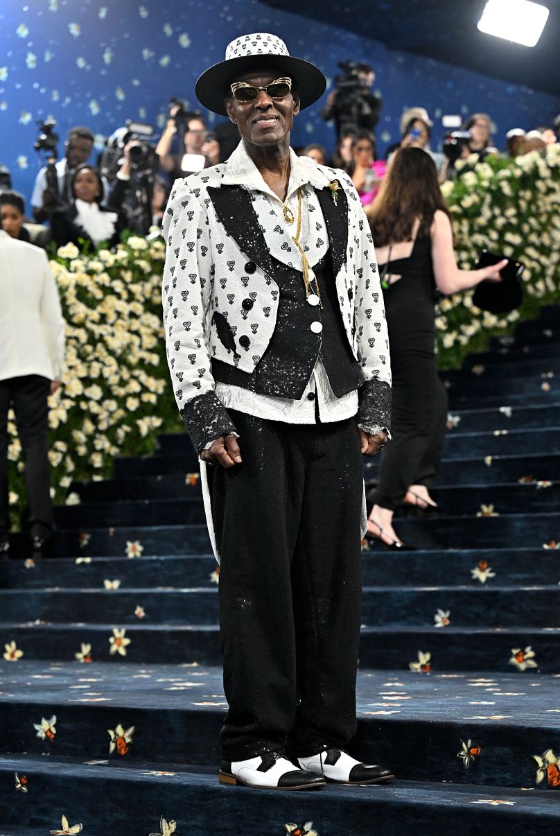El ícono de la moda urbana, Dapper Dan, lució un traje zoot blanco y negro personalizado, con un pájaro Sankofa como homenaje a sus raíces y ascenso.