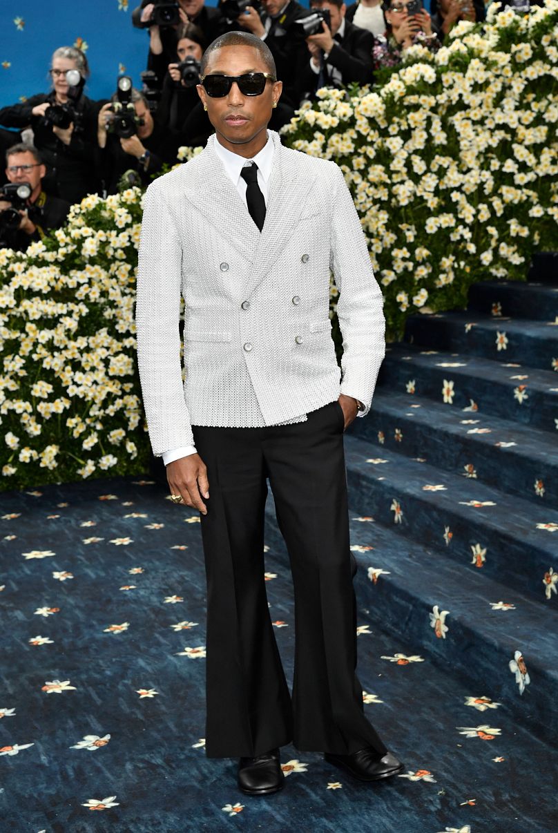 Louis Vuitton'un erkek giyim kreatif direktörü Pharrell Williams, inci işlemeli, çizgili efektli, kruvaze bir ceket giydi.
