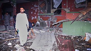 Local residents examine a building damaged from a suspected Indian missile attack near Muzaffarabad, the capital of Pakistan controlled Kashmir, in Wednesday, May 7, 2025