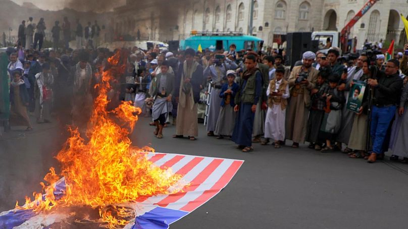 حوثی‌ها در حال آتش زدن پرچم آمریکا در صنعا