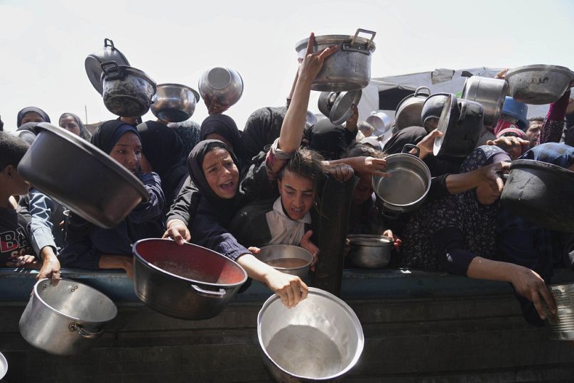 فلسطينيون يتدافعون للحصول على مساعدات غذائية في خان يونس، 5 أيار/مايو 2025.