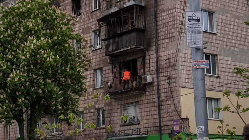 Bir belediye çalışanı, Kiev'de Rus saldırısı sonucu hasar gören bir konut balkonundan molozları temizliyor, 7 Mayıs 2025.