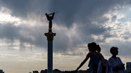 The sun sets behind the Independence Monument overlooking Maidan Square on the country's National Flag Day, Tuesday, Aug. 23, 2022, in Kyiv, Ukraine.