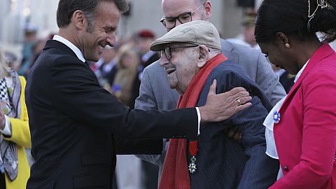 French President Emmanuel Macron awards French WWII resistant Jean Daikhowski with the Legion of Honor during ceremonies marking the 80th anniversary of the end of WWII